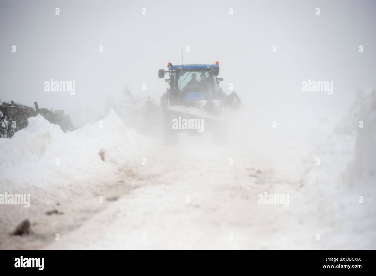 Farmer on a New Holland tractor clearing snow off rural road after a ...