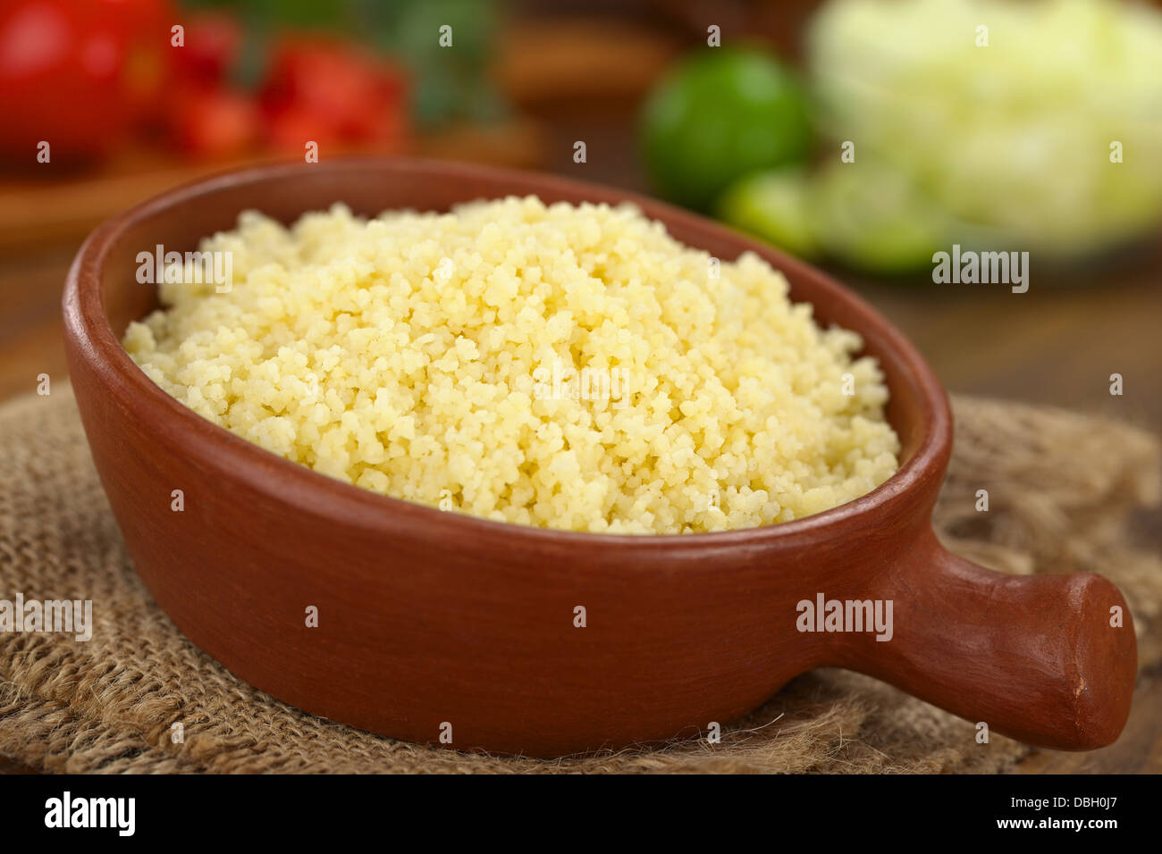 Prepared couscous in rustic bowl (Selective Focus, Focus one third into the couscous) Stock Photo