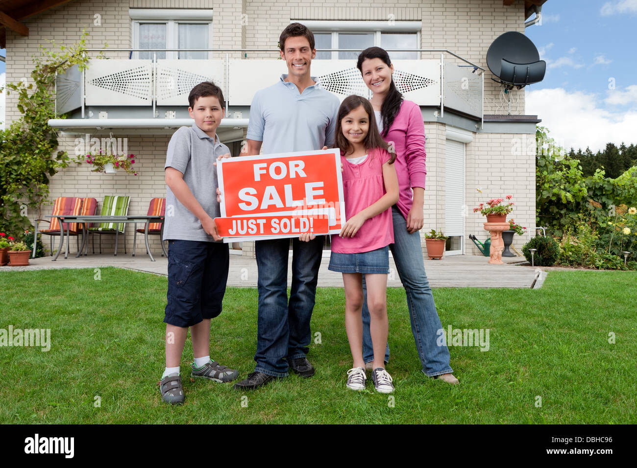 Famille heureuse devant leur nouvelle maison