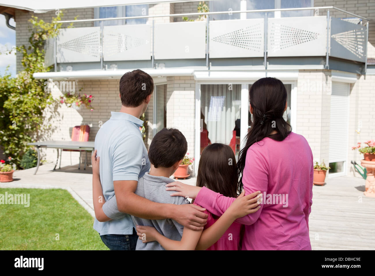 Young family standing in front of their dream home Stock Photo - Alamy