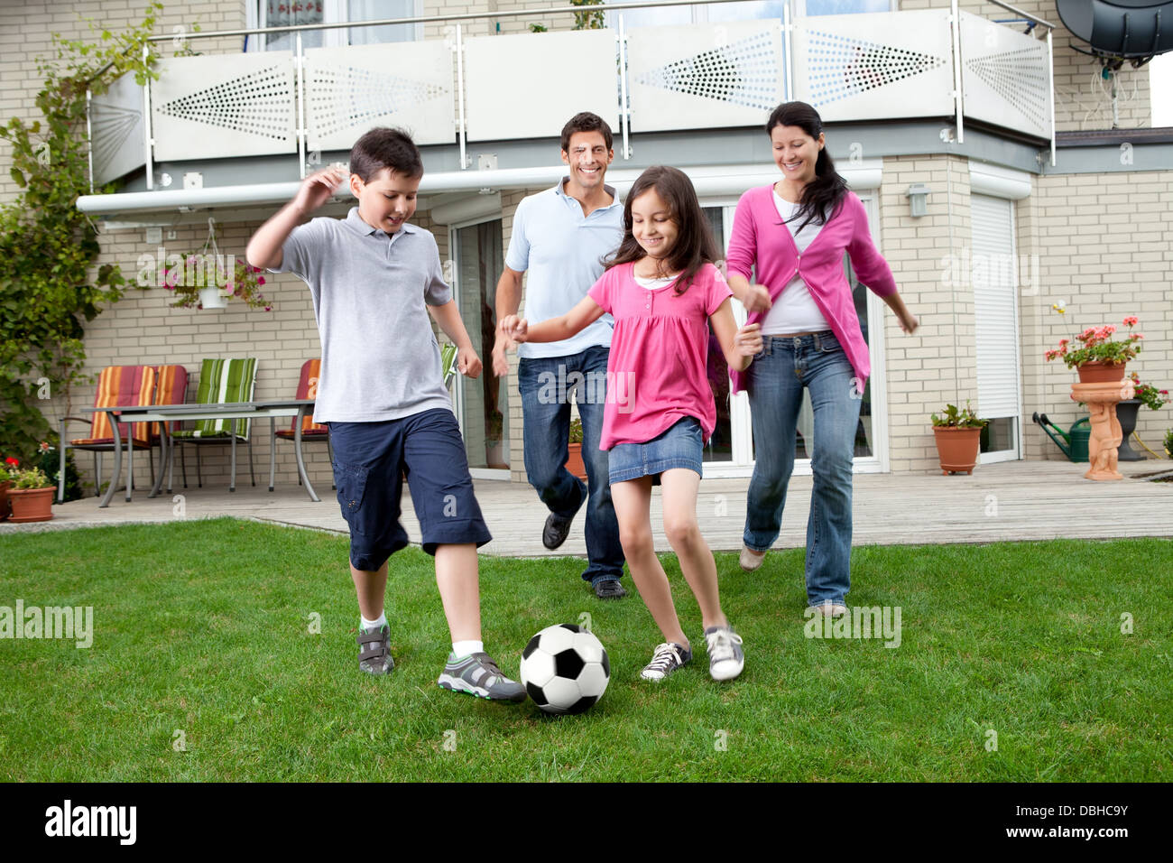 Happy family playing football in their backyard Stock Photo - Alamy