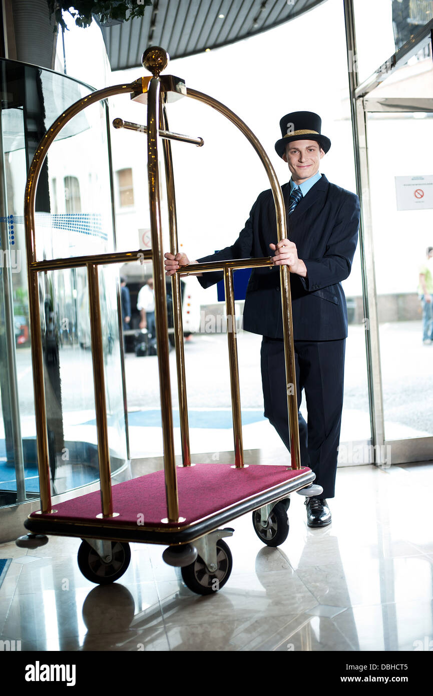 Profile shot of a doorman holding a cart Stock Photo