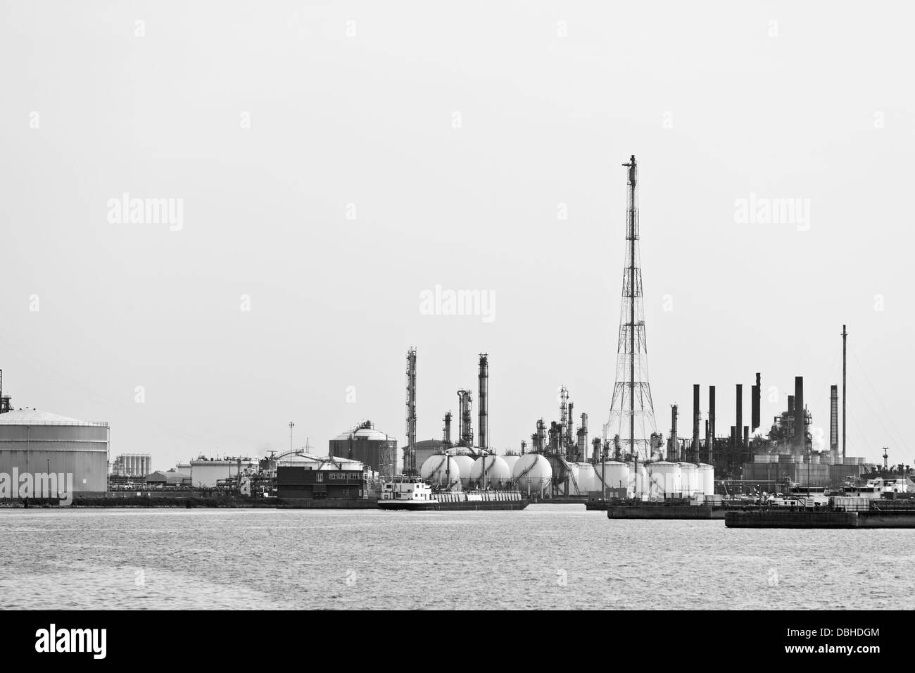 Distillation towers and oil storage tanks in a refinery during daytime, black and white shot. Stock Photo