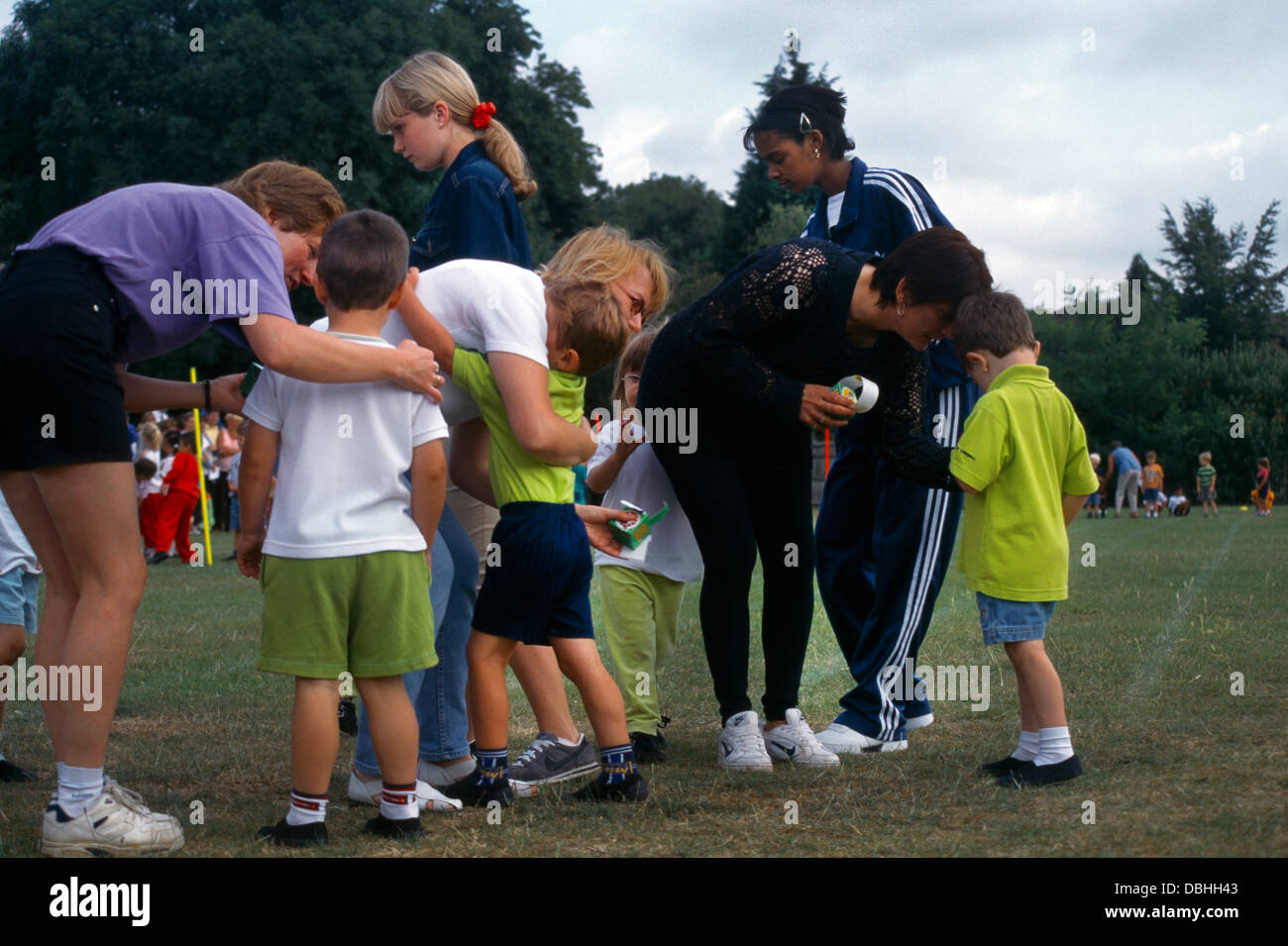 School Sports Day Primary School Teenagers Helping Awarding The Children With Winners Stickers Stock Photo