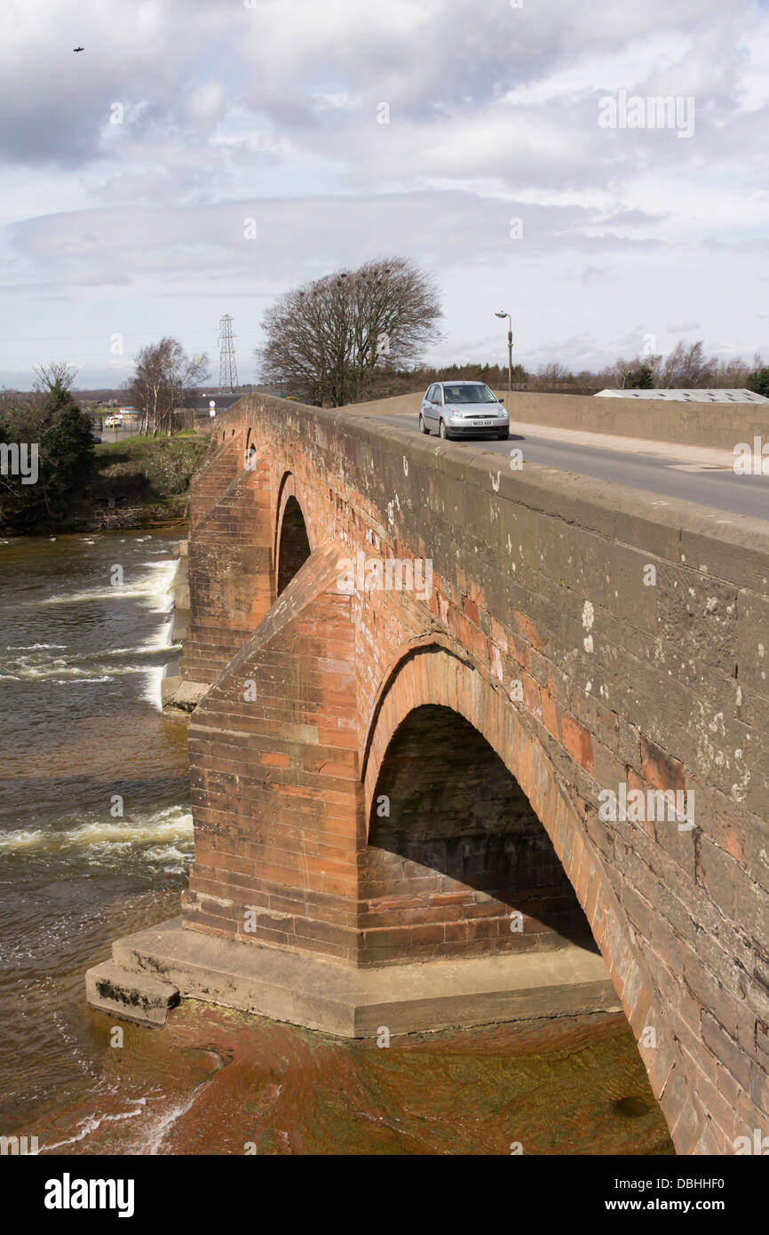 Stone five arch bridge carrying a car on the A7 over the River Esk at Longtown in Cumbria, England. Stock Photo
