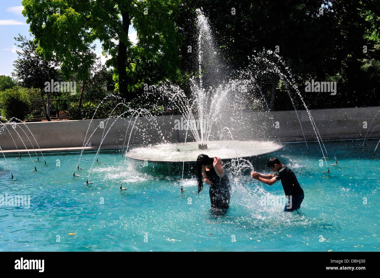 Two children playing at Marble Arch fountains, London, UK Stock Photo
