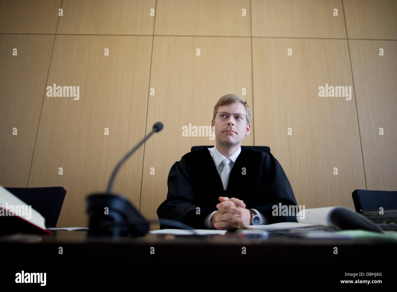 Presiding judge Tobias Rundel sits in a court room of the lower regional court in Duesseldorf, Germany, 31 July 2013. If a tenant bothers a neighbour with cigarette smoke, this can be legal cause to terminate his lease of the apartment. The case at hand was about tenant Friedhelm Adolfs, whose leasse on his apartment was cancelled after 40 years. Photo: ROLF VENNENBERND Stock Photo