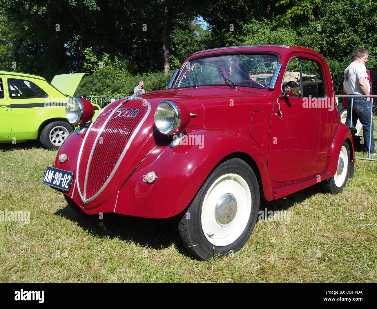 This image showcases a 1948 Fiat 500B, a classic car displayed at a vintage car show. The Fiat 500B represents an iconic example of post-WWII European automotive design. Stock Photo
