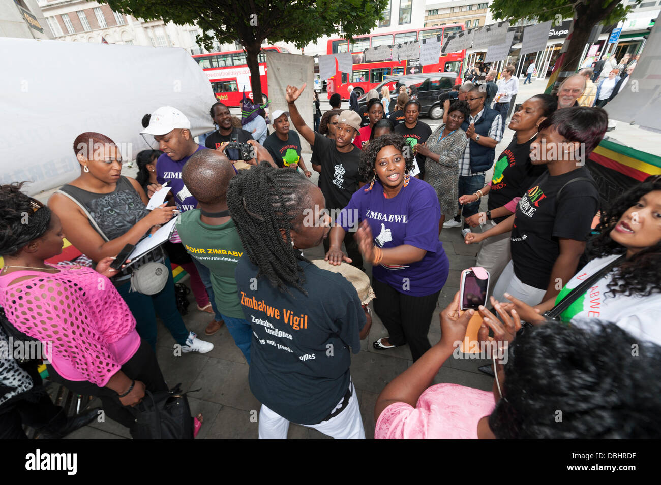 London, UK. 31st July, 2013. Demonstrators hold a song and dance vigil in London. Today Zimbabwe goes to the polls in a general election which many believe will be rigged by the current president, Robert Mugabe. Credit:  Lee Thomas/Alamy Live News Stock Photo
