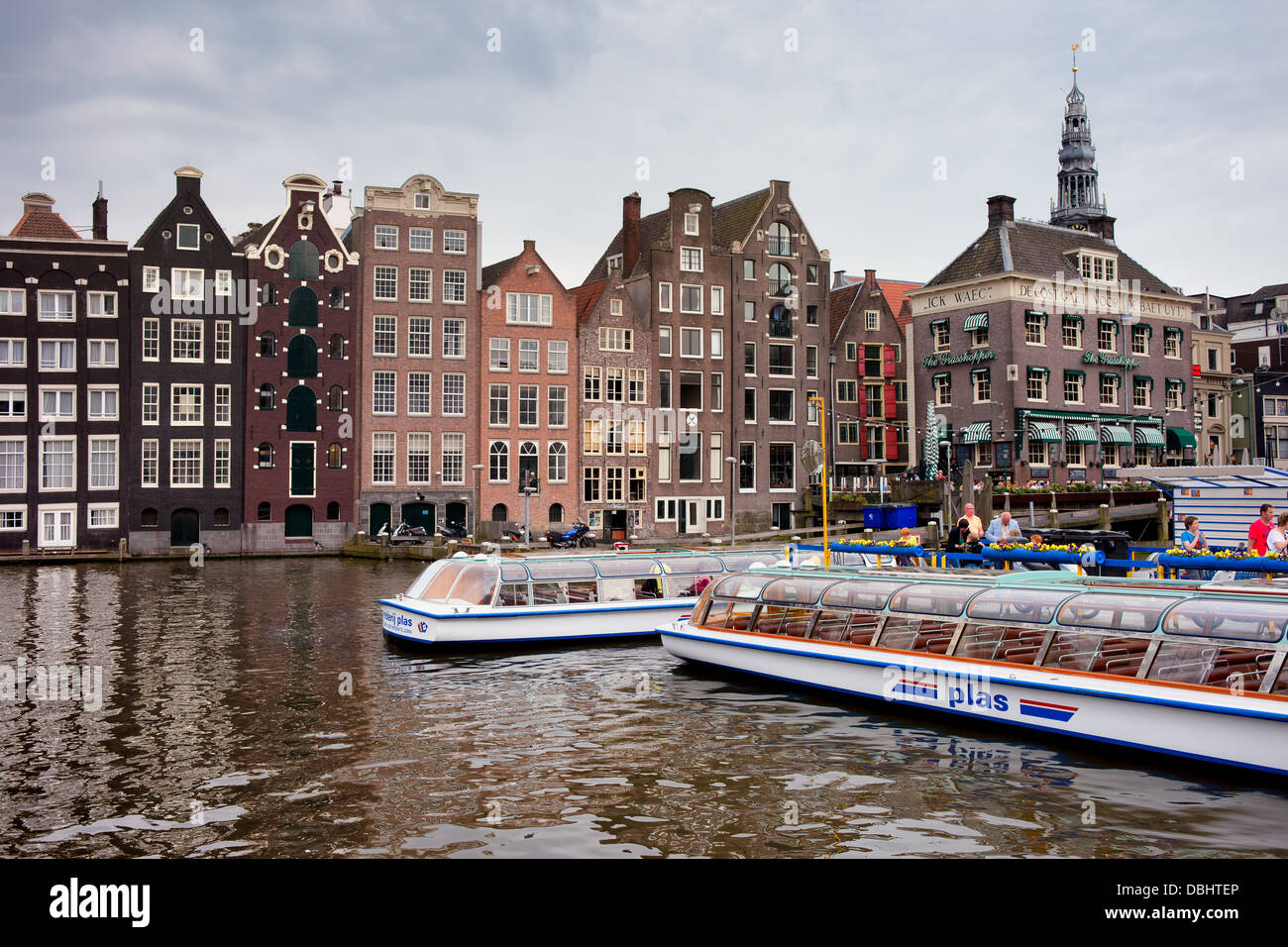 Hisitoric houses on the water and passenger boats in Amsterdam, Holland, Netherlands. Stock Photo