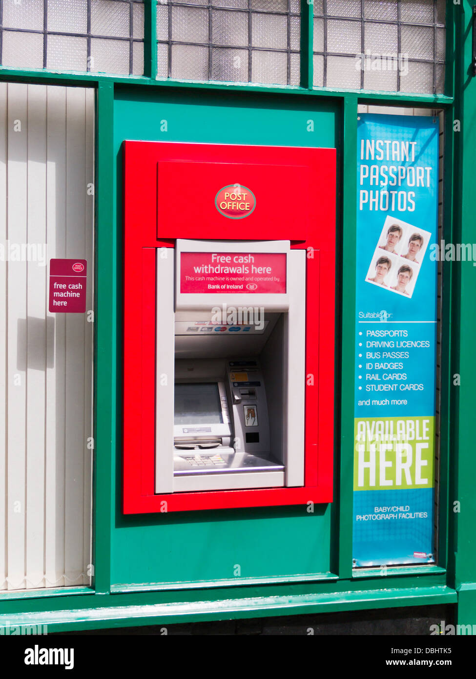 A red English Post Office Bank of Ireland ATM hole in the wall money machine Stock Photo