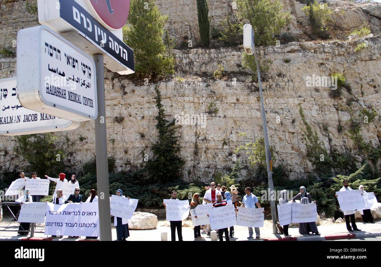 Jerusalem, West Bank, Palestinian Territory. 30th July, 2013. Palestinian students of medical colleges in Jerusalem's al-Quds University hold placards during a protest against the Israeli Health ministry demanding to confess of their certificates and allow them to work in Israeli hospitals, in front of Hadassah medical center, in Jerusalem July 31, 2013 Credit:  Saeed Qaq/APA Images/ZUMAPRESS.com/Alamy Live News Stock Photo