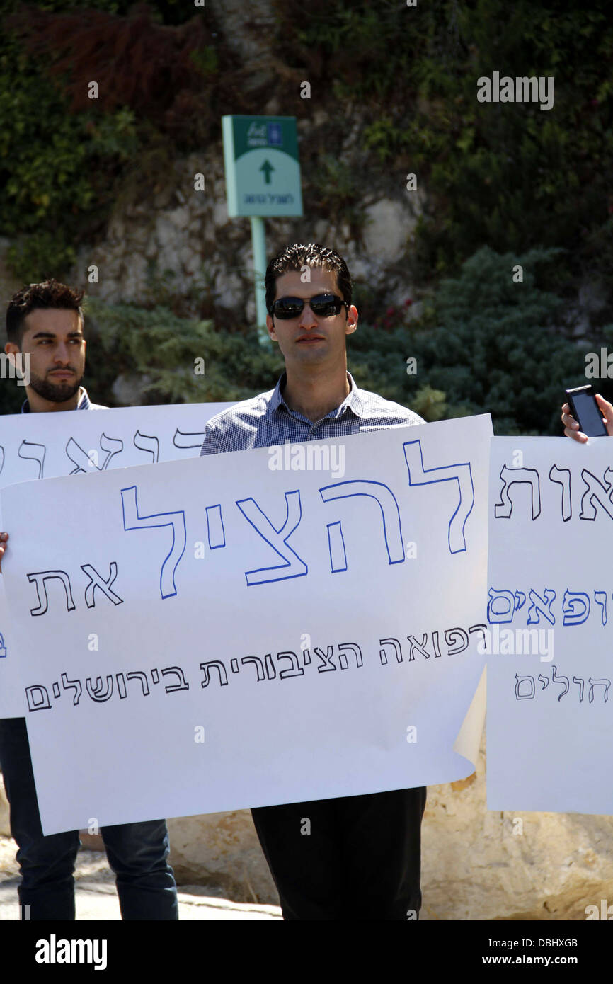 Jerusalem, West Bank, Palestinian Territory. 30th July, 2013. Palestinian students of medical colleges in Jerusalem's al-Quds University hold placards during a protest against the Israeli Health ministry demanding to confess of their certificates and allow them to work in Israeli hospitals, in front of Hadassah medical center, in Jerusalem July 31, 2013 Credit:  Saeed Qaq/APA Images/ZUMAPRESS.com/Alamy Live News Stock Photo