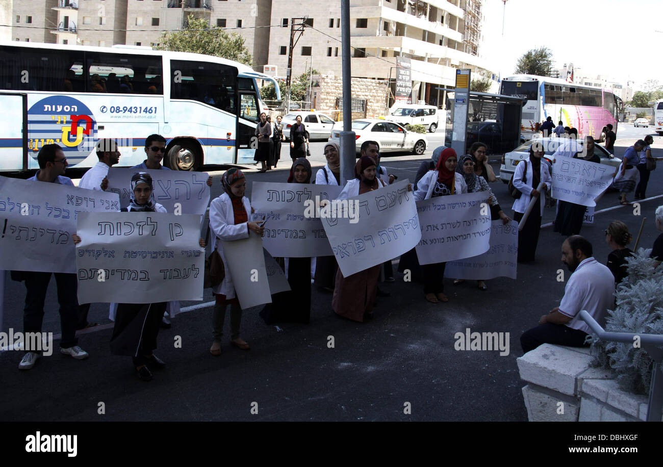 Jerusalem, West Bank, Palestinian Territory. 30th July, 2013. Palestinian students of medical colleges in Jerusalem's al-Quds University hold placards during a protest against the Israeli Health ministry demanding to confess of their certificates and allow them to work in Israeli hospitals, in front of Hadassah medical center, in Jerusalem July 31, 2013 Credit:  Saeed Qaq/APA Images/ZUMAPRESS.com/Alamy Live News Stock Photo