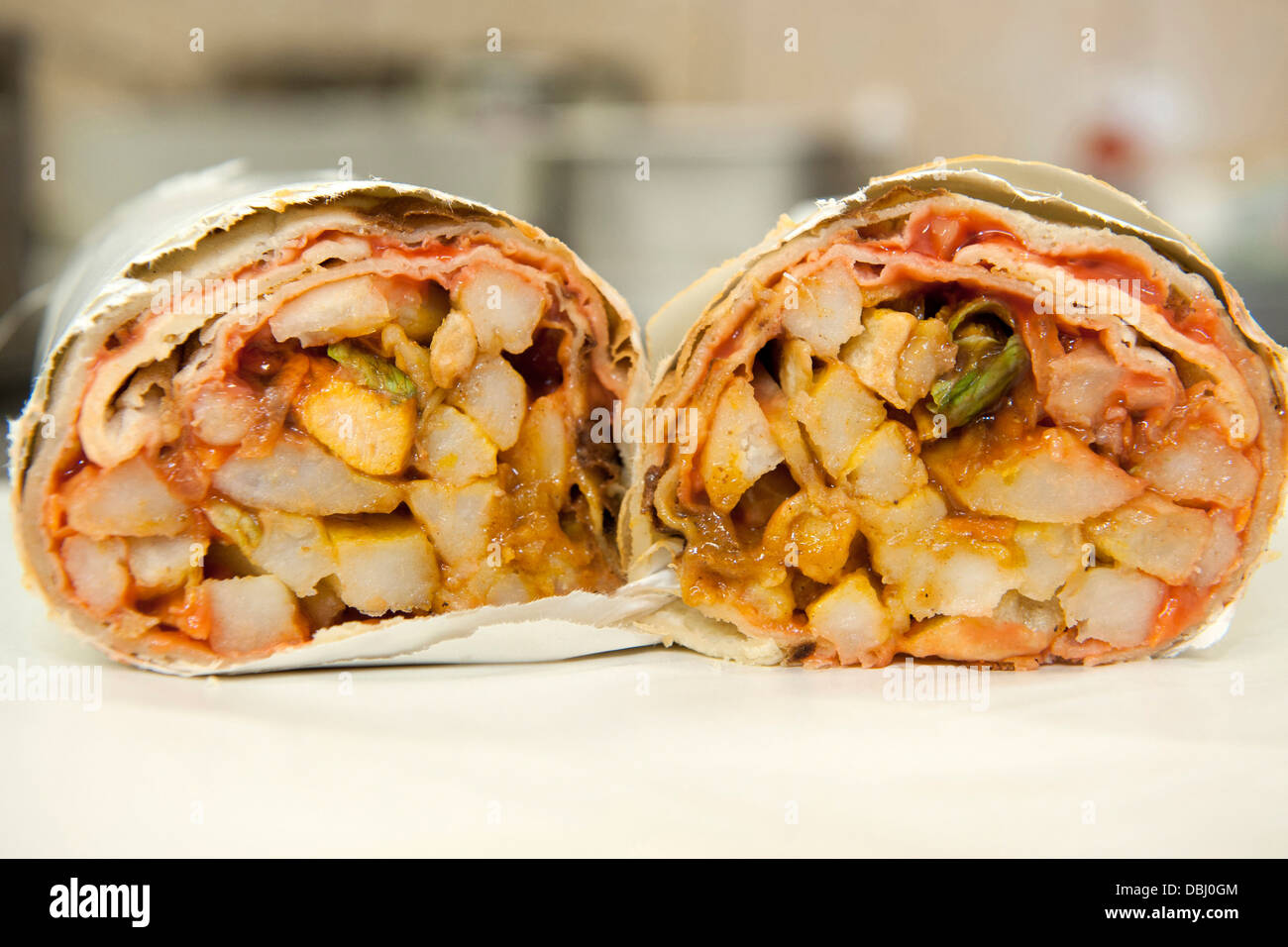 Wrapped chicken roti gatsby cut to show the contents at Sunshine Chip