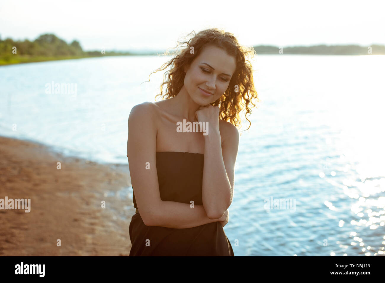Beautiful girl walks and dreams on the banks of the deep blue river ...