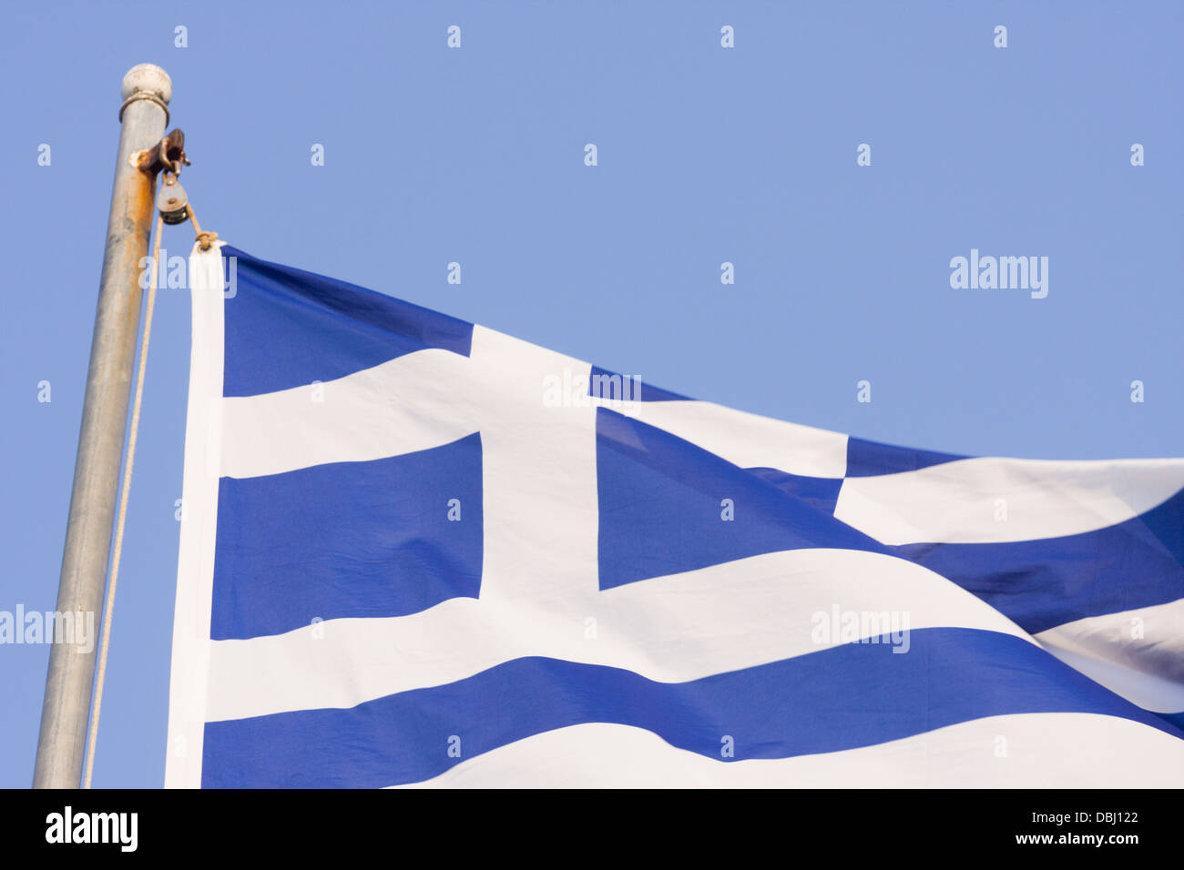 Greek flag flying in breeze on flag pole Stock Photo