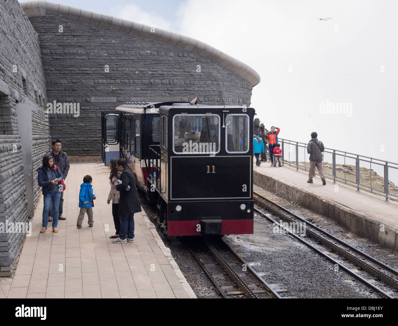 Tourists on platform by Snowdon Mountain Railway train at Hafod Eryri summit station on Mount Snowdon in Snowdonia Wales UK Stock Photo