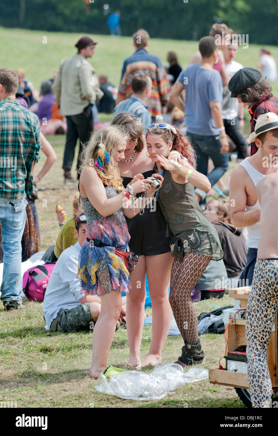Glastonbury Festival 2013 UK - Three girls review a photograph near the stone circle. Stock Photo