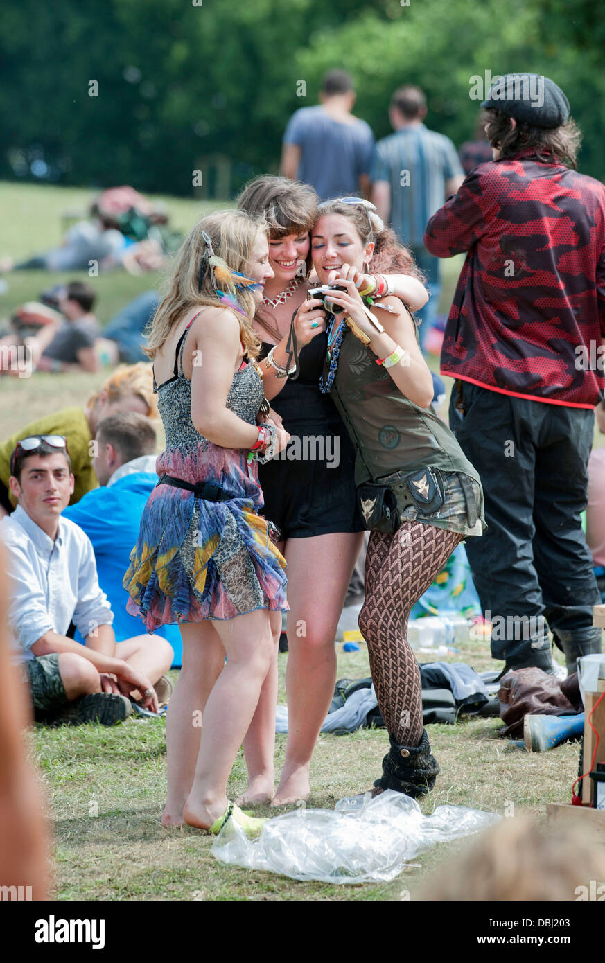Glastonbury Festival 2013 UK - Three girls review a photograph near the stone circle. Stock Photo