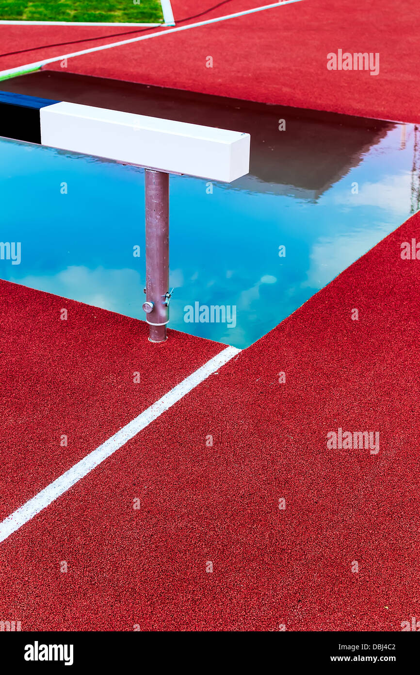 Athletic track with hurdle to jump over water Stock Photo