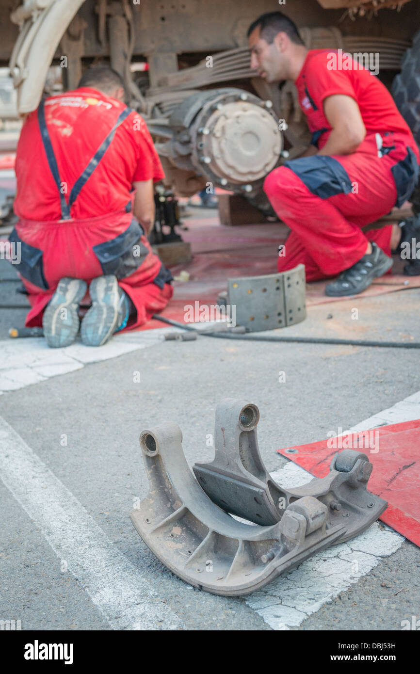 Team mechanics working in truck brakes during 2013 Baja Aragon. Stock Photo