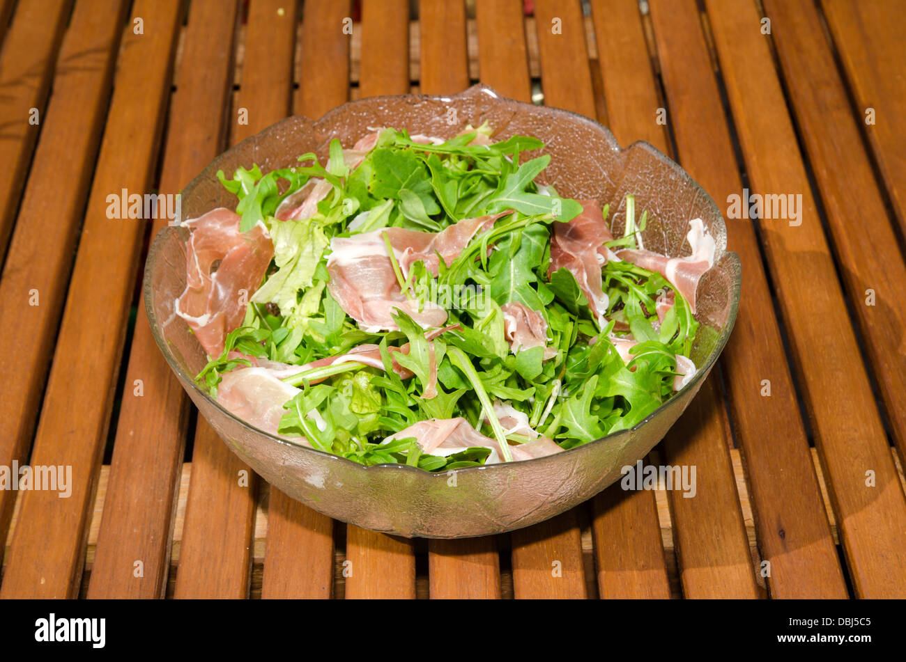 Bowl with fresh salad and ham on a table Stock Photo