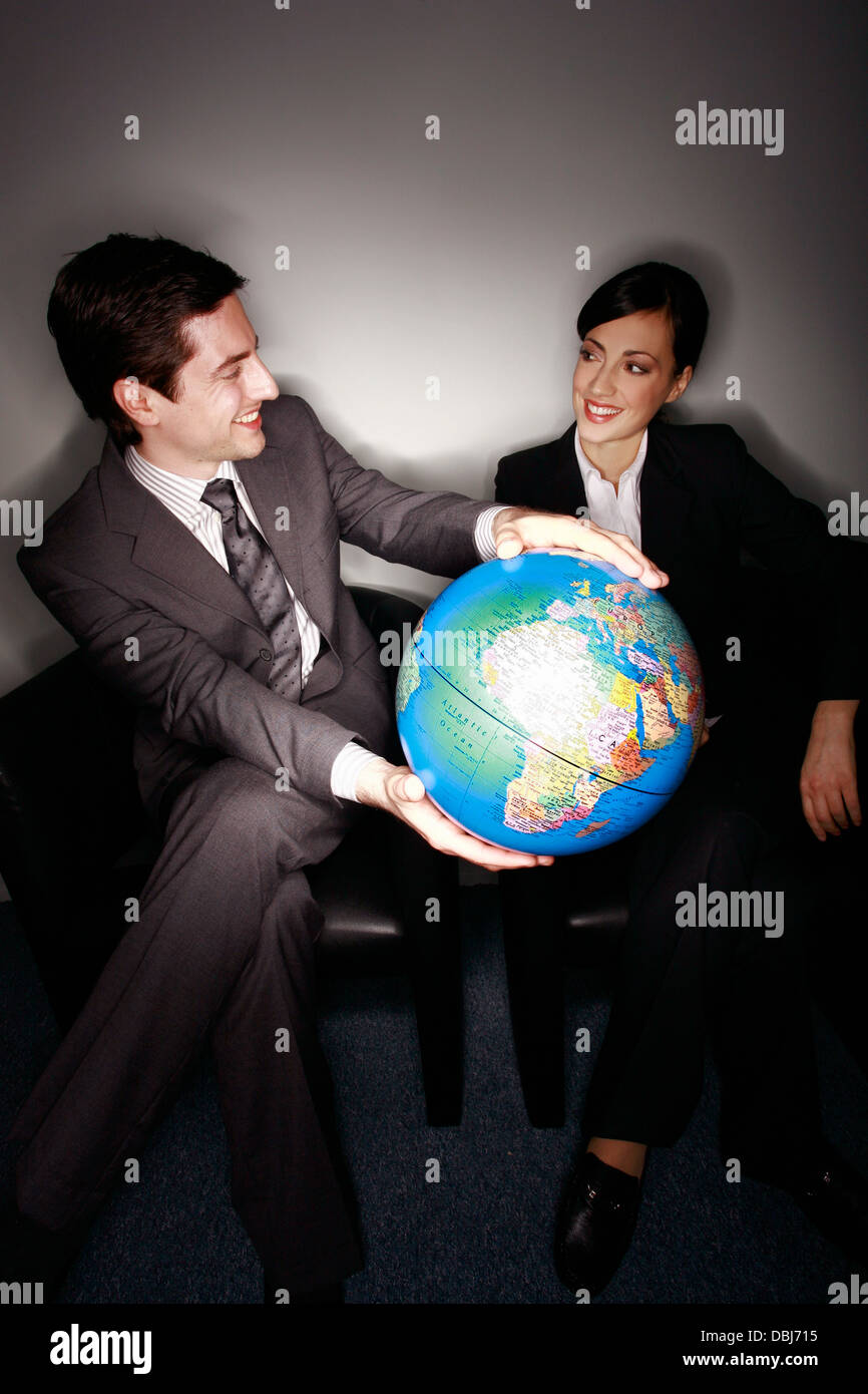 Male and female businesspeople with globe Stock Photo - Alamy