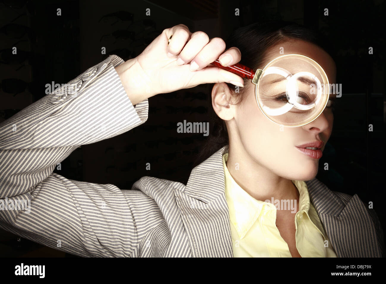 Woman with magnifying glass on eye Stock Photo - Alamy