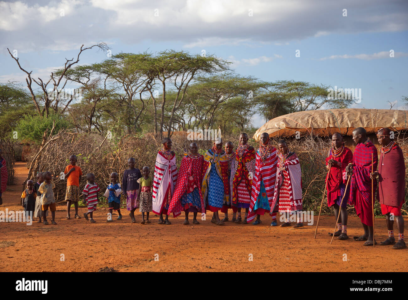 Masai Villagers in traditional clothing outside boma. Ol Kinyei Conservancy area. Kenya, Africa. Stock Photo