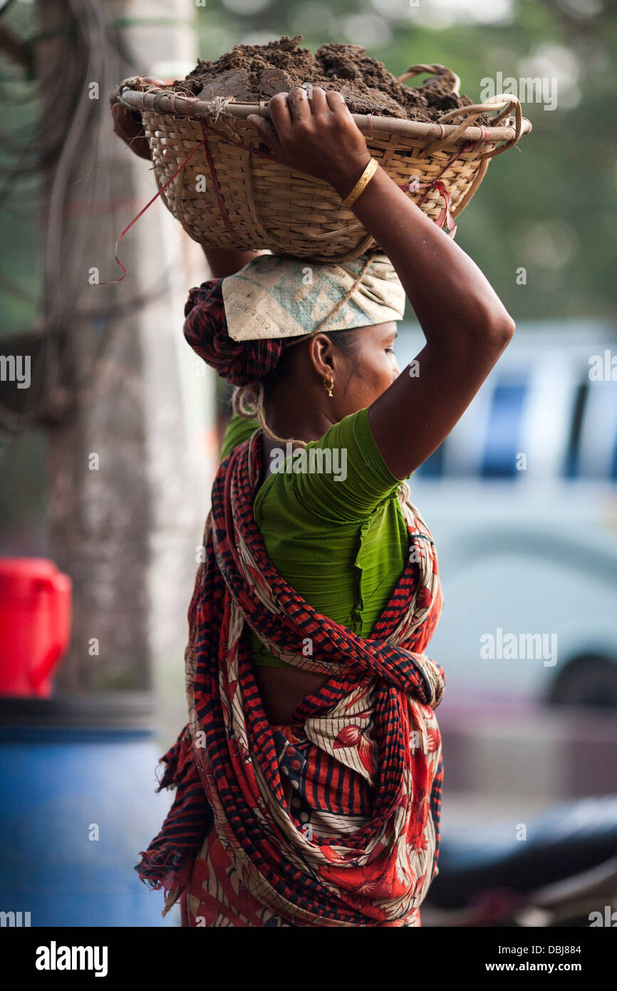 Rural Bangladeshi women perform manual labor carrying dirt for three