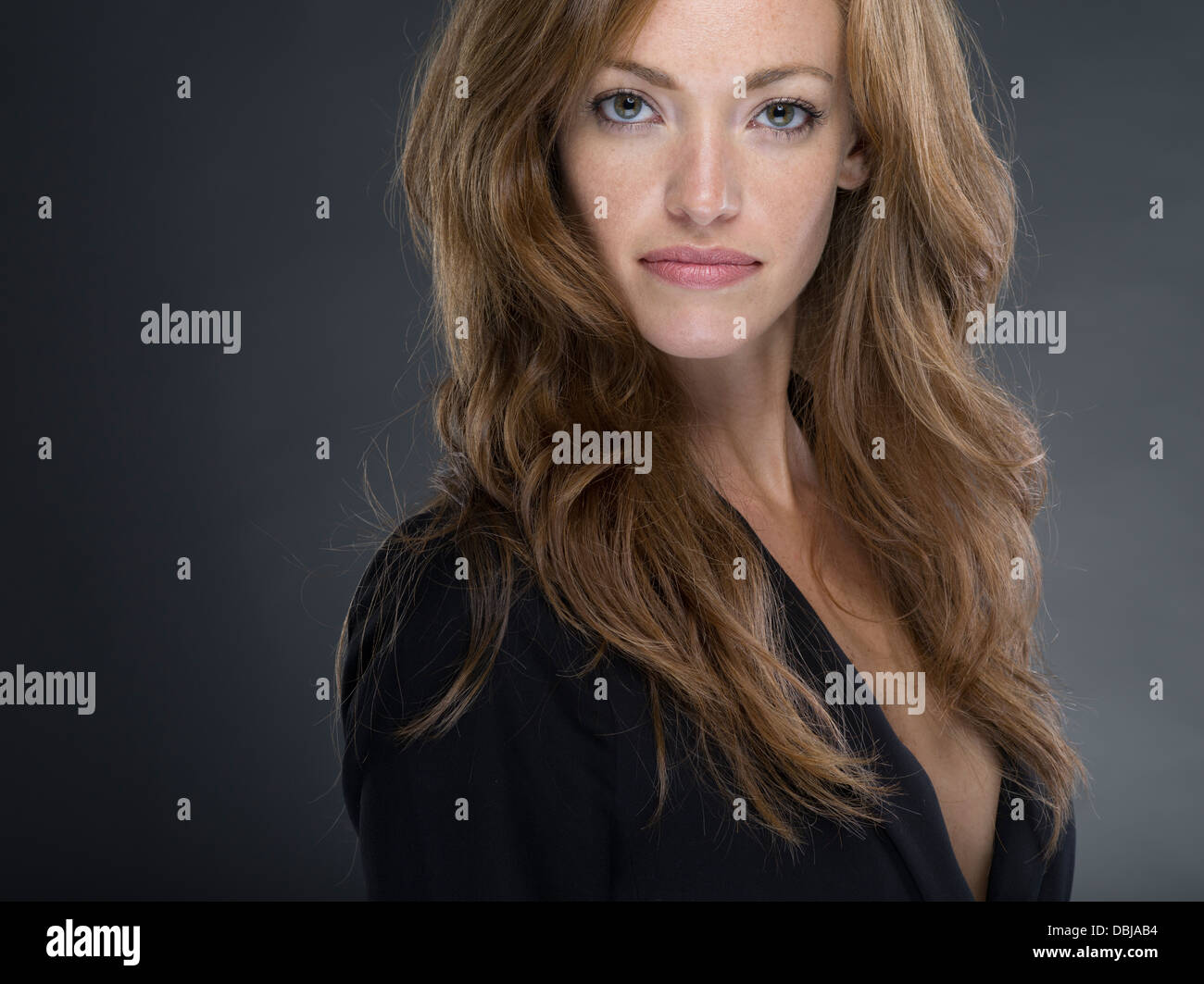 Young Caucasian woman with strawberry blond hair wearing black jacket looking at camera Stock Photo