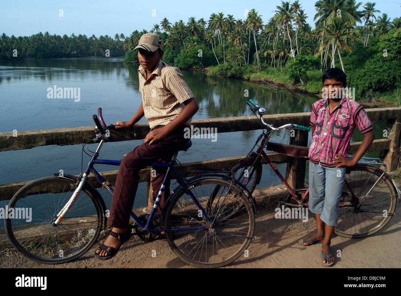 Local Village Boys with their cycle above kerala backwaters India Stock Photo