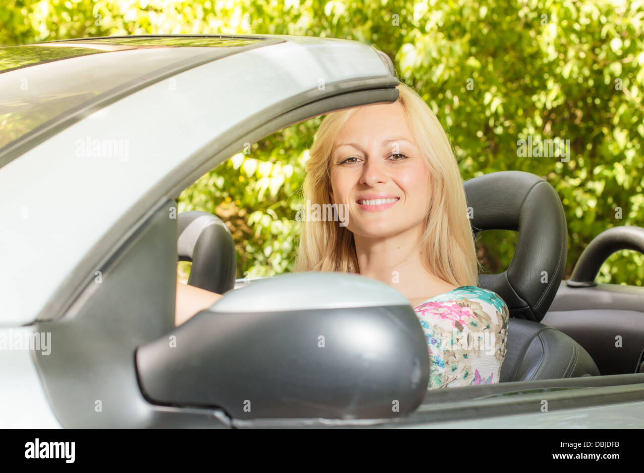 Cheerful beautiful young woman in the car Stock Photo - Alamy