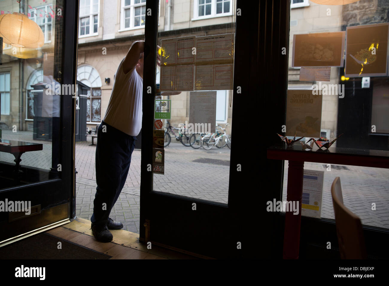 Chef looking out of restaurant door, Rose Street, Edinburgh, Scotland Stock Photo