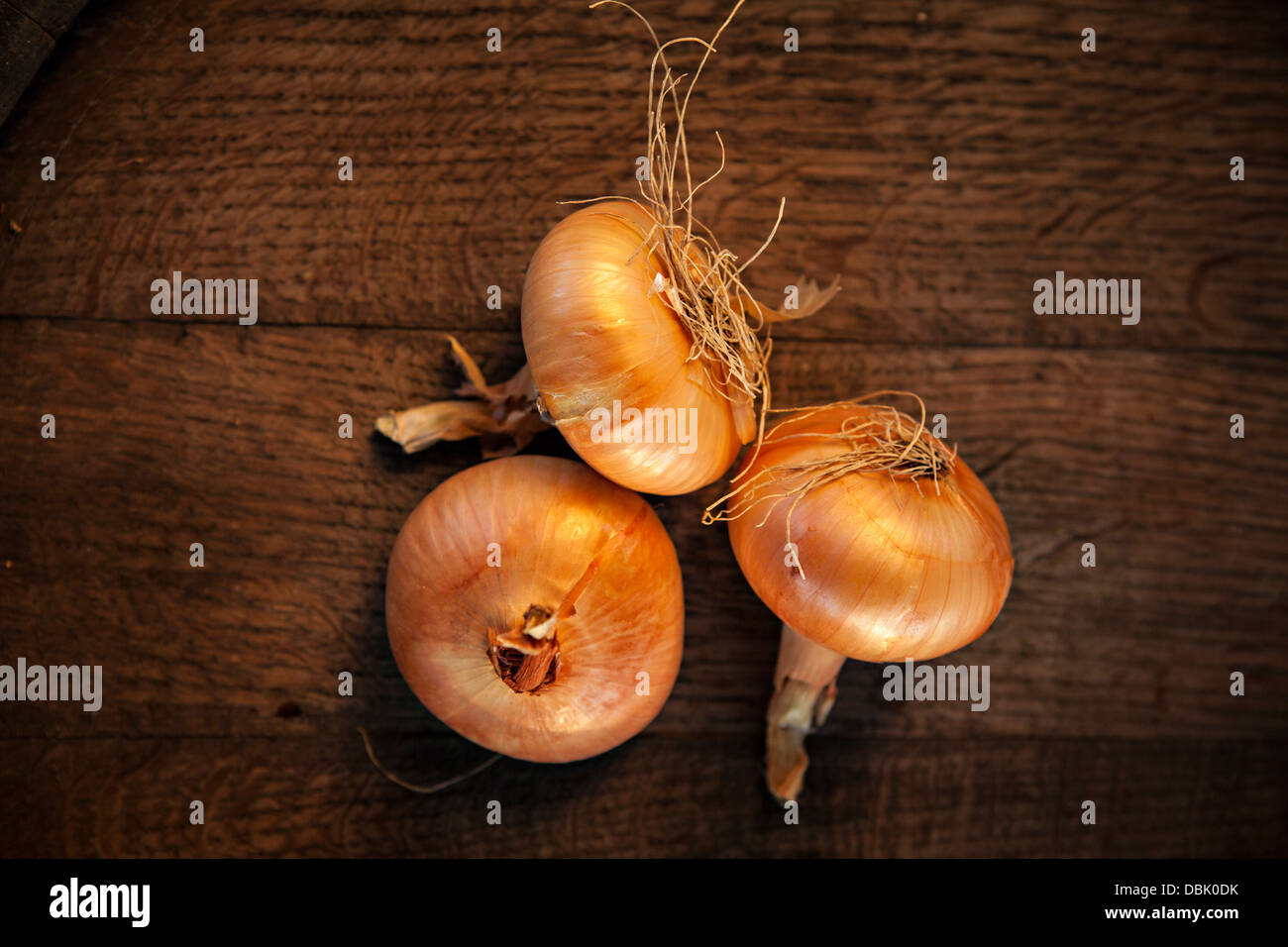 Three Onions On Wooden Table, Croatia, Slavonia, Europe Stock Photo