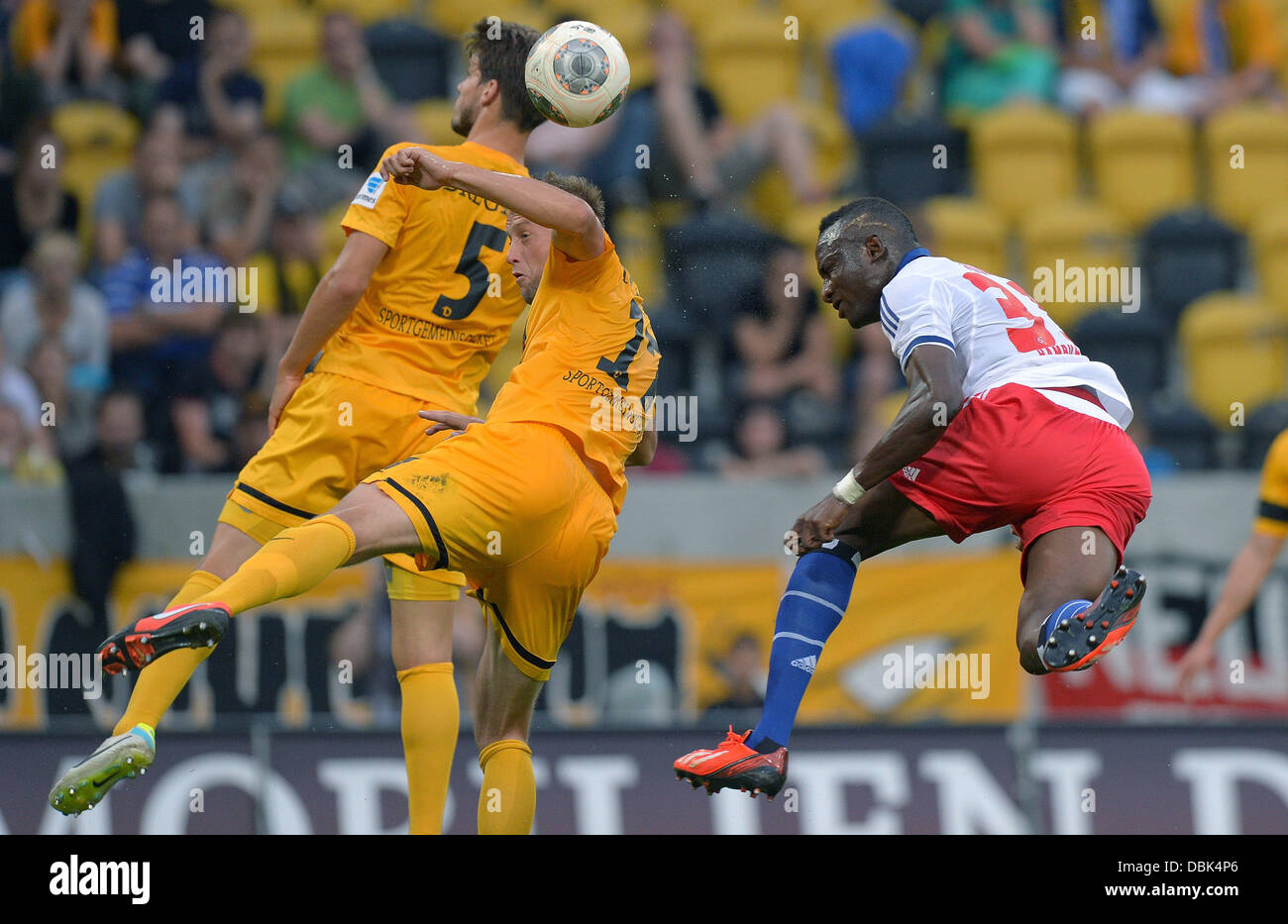 Dresden, Germany. 31st July, 2013. Dresden's Romain Bregerie (L) nd Adnan Mravac (C) vie for the ball with Hamburg's Jacques Zoua during a benefit match between SG Dynamo Dresden and Hamburger SV at gluecksgas stadium in Dresden, Germany, 31 July 2013. The earnings of the match go to victims of the recent floodings in Germany, according to the organisers. Photo: Thomas Eisenhuth/dpa/Alamy Live News Stock Photo