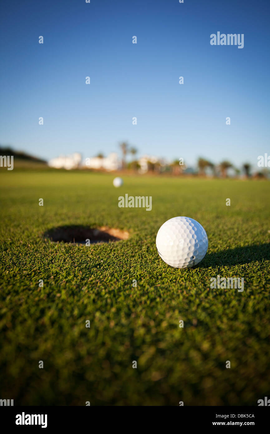 Golf ball on the green next to the hole Stock Photo Alamy