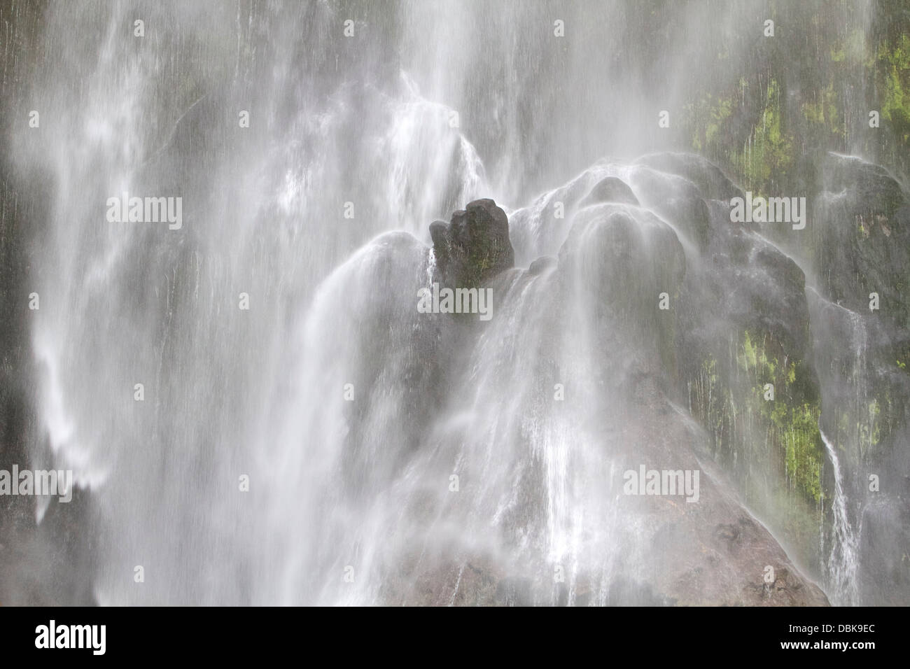 Rocks at the base of Stirling Falls in Milford Sound, Fiordland National Park, New Zealand. Stock Photo