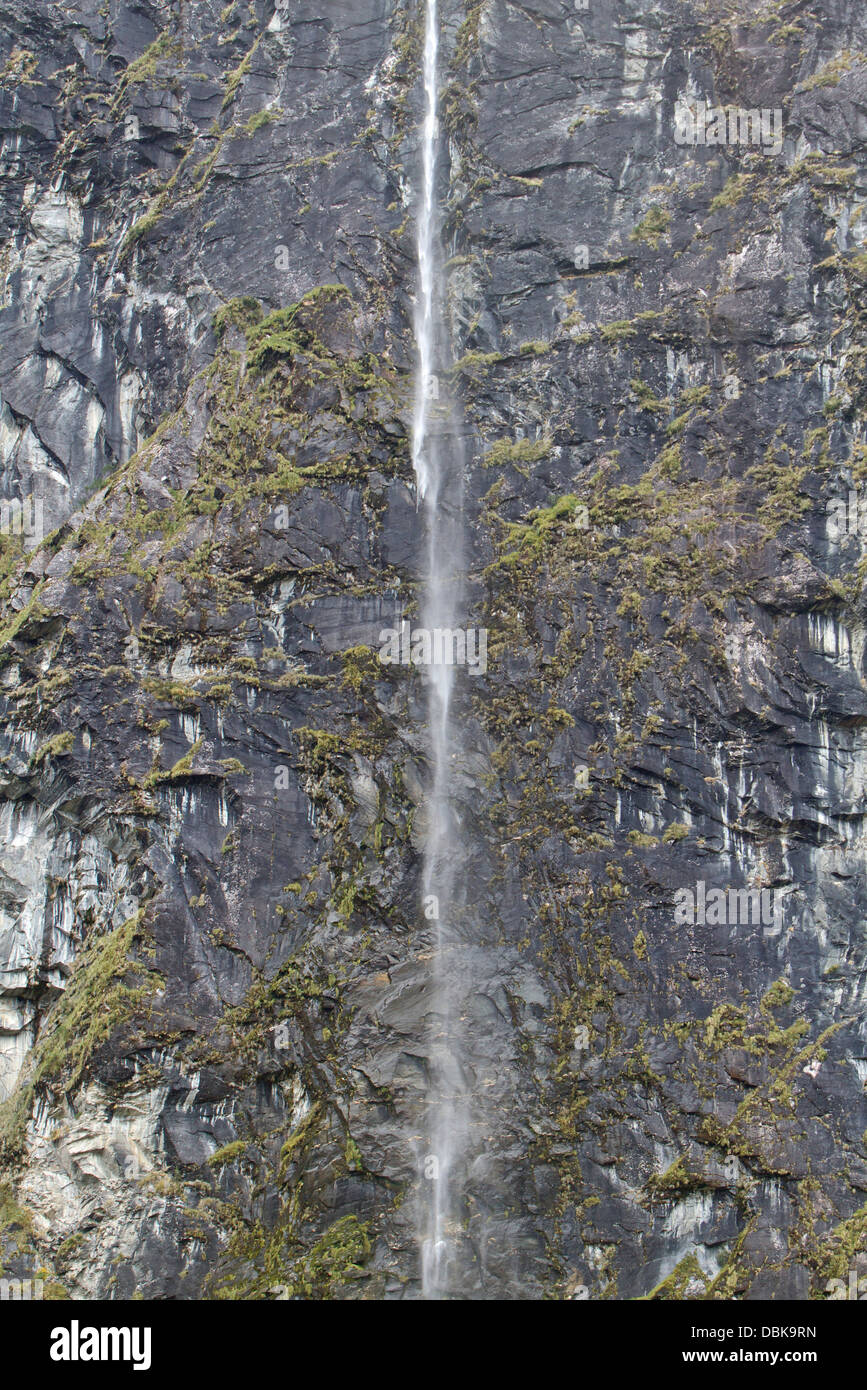 Water cascades down a sheer cliff face in the Rob Roy Valley, Mount Aspiring National Park, New Zealand. Stock Photo
