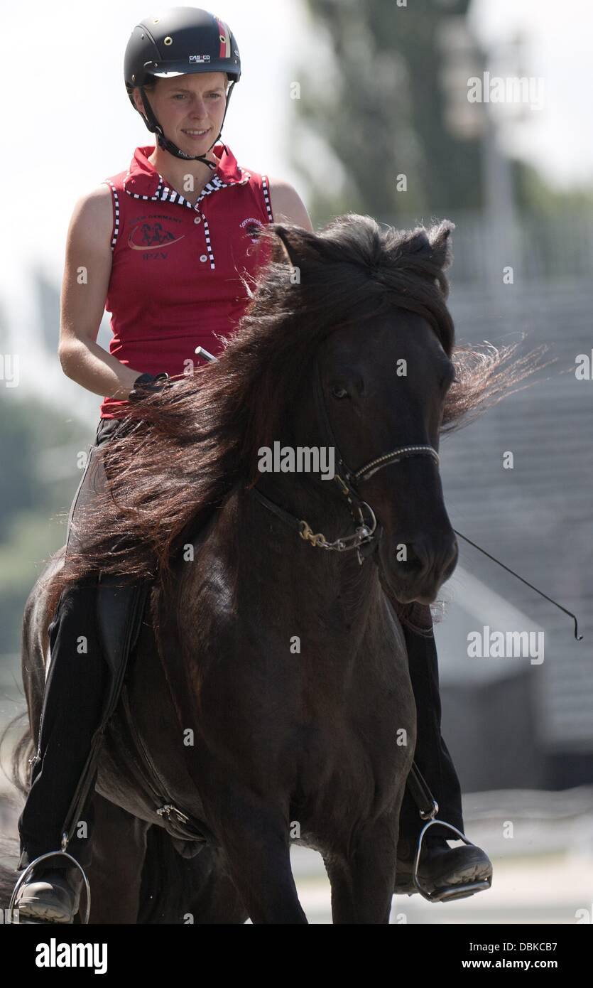 Frauke Schenzel rides her stallion Vauli during a practice session at the trotting course in Berlin-Karlshorst, Germany, 01 August 2013. The Iceland horse world championships take place in Berlin between 04 and 11 AUgust 2013. Photo: Joerg Carstensen Stock Photo