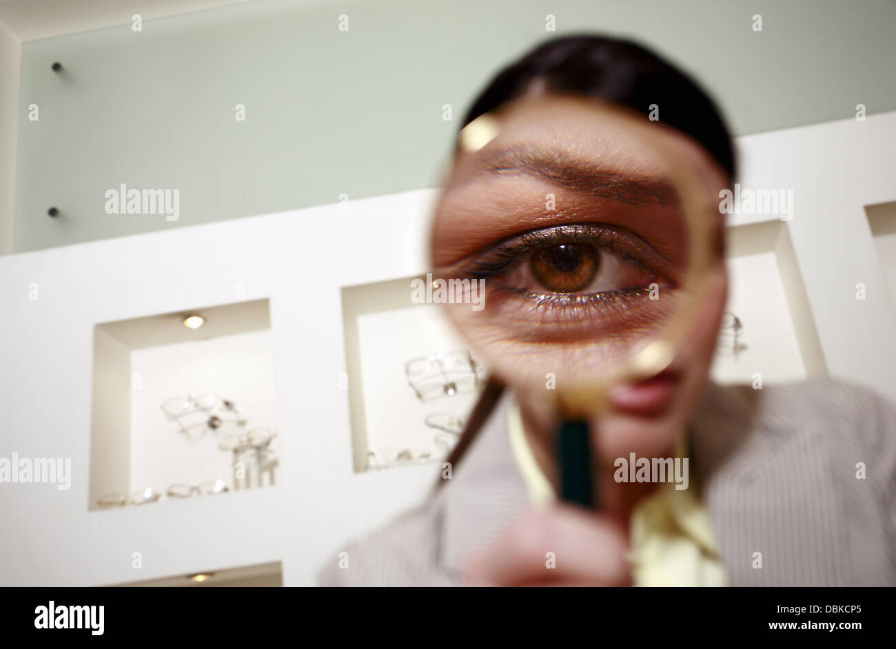 Woman with magnifying glass on eye Stock Photo - Alamy