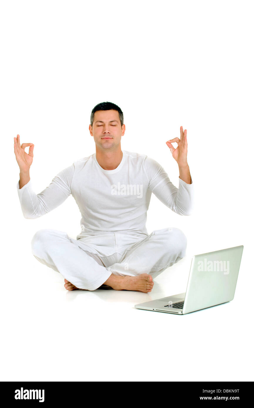 man dressed in white sitting on the floor practicing yoga with l Stock ...
