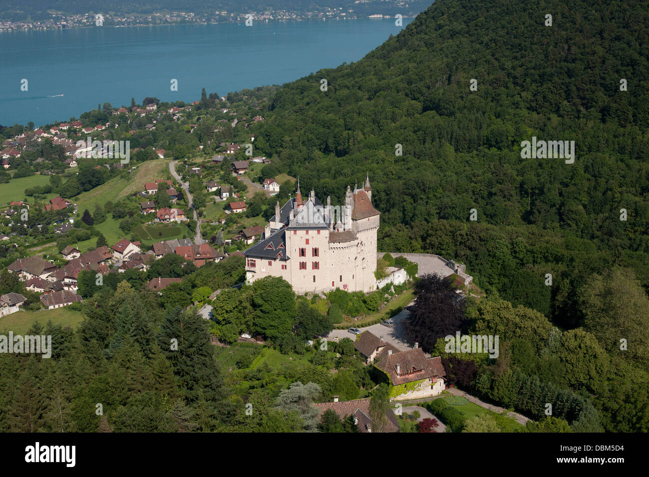 AERIAL VIEW. Medieval castle overlooking the turquoise water of Lake Annecy. Menthon-Saint-Bernard Castle, Haute-Savoie, Auvergne-Rhône-Alpes, France. Stock Photo