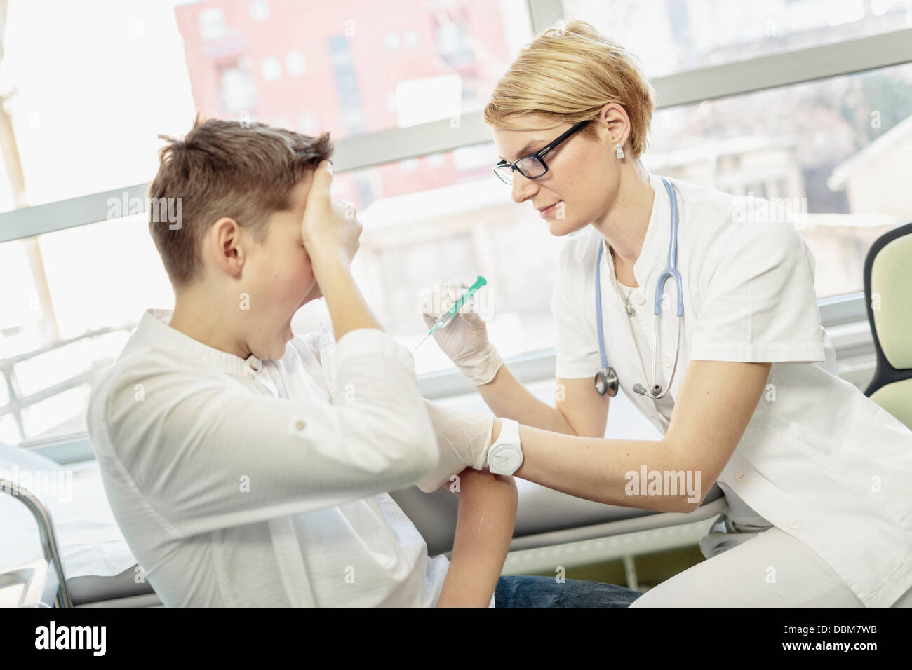 Female doctor giving anxious boy a shot, Osijek, Croatia Stock Photo