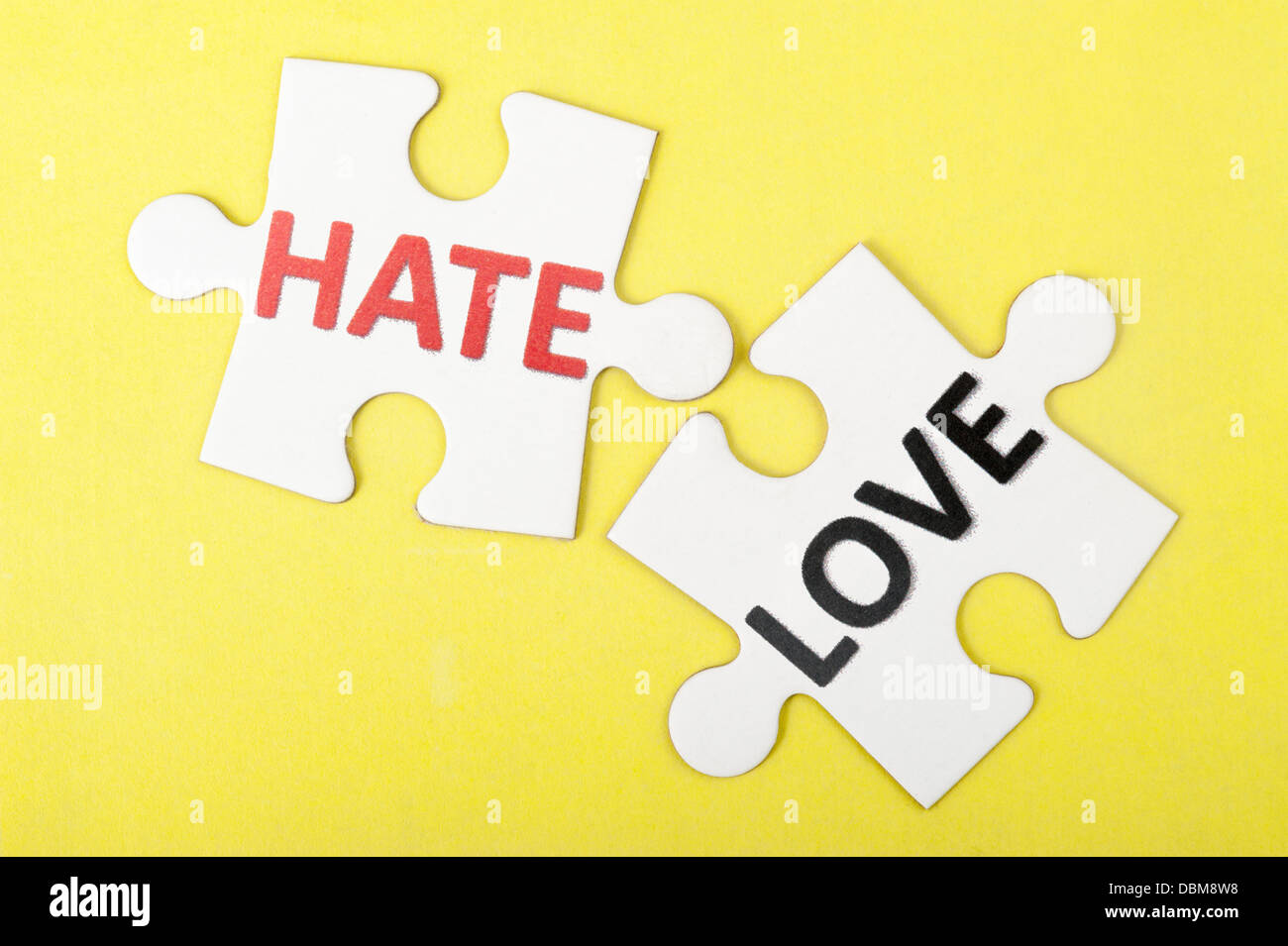 Hate versus love concept words on two pieces of jigsaw puzzle Stock Photo