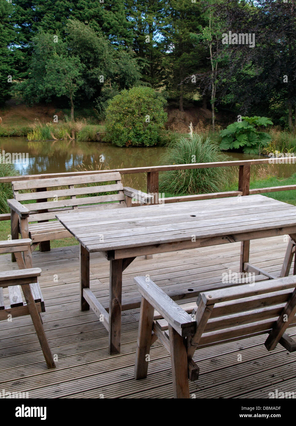 Wooden garden table and chairs by a lake, Devon, UK 2013 Stock Photo