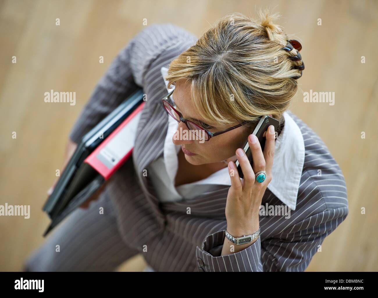 (ILLUSTRATION) An illustration shows a business woman with a folder and laptop under her arm while talking on a smartphone in Frankfurt Oder, Germany, 31 July 2013. Photo: PATRICK PLEUL Stock Photo