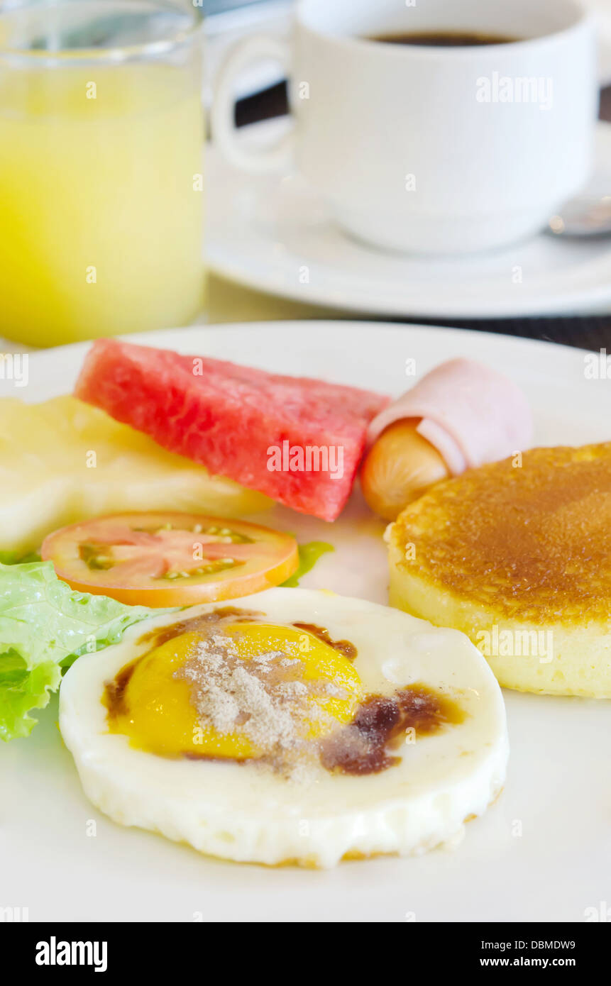 full meal for breakfast ( pancake , fried egg , ham and sausage , fresh