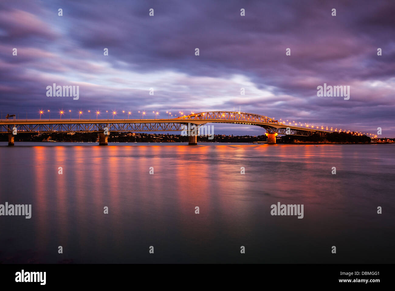 Auckland Harbour Bridge - Auckland Harbor Bridge with its lights on at twilight. Stock Photo
